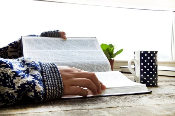 Женщина руки чтение книги с кофе — стоковое фото