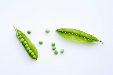 Beyaz arkaplanda taze yeşil bezelyeler.
