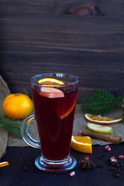 portakal, elma ve baharat dilimli şarap, tarçın ve anason yıldızlı ahşap bir arka planda kış süslemeleri. Kışın ve sonbaharın sıcak içecekleri. dikey