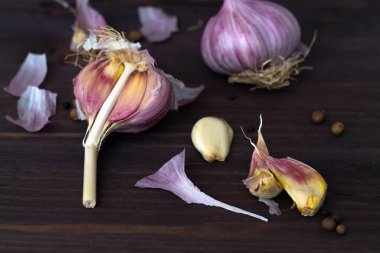Taze sarımsak ve karabiber. Karanlık bir masada soyulmamış taze sarımsak. sağlıklı ve sağlıklı yiyecekler. Taze sarımsak ve ahşap bir arka planda. yatay yönelim.