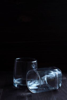 alcoholic drinks. empty glass for whiskey on a black background. two glasses for whiskey on a wooden background. horizontal orientation