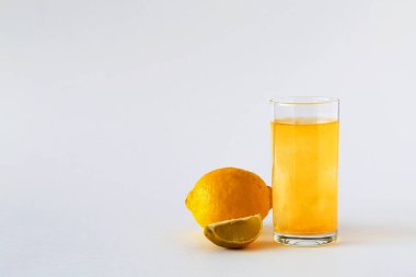 Cam içinde C vitamini hapları, beyaz arka planda su, taze limon ve limon. Limonlu turunçgil meyvesi ve beyaz masa. Bağışıklık sistemini güçlendirmek için. Sağlıklı bir yaşam tarzı. Boşluğu kopyala.