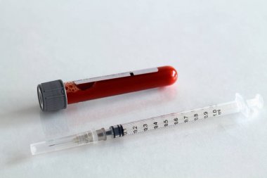 Tıbbi şırınga ve beyaz arka planda kan izole edilmiş test tüpü. Sağlık sigortası. Coronavirus karantinası, hijyen konsepti. Koronavirüsü önle. Üst Manzara. Boşluğu kopyala