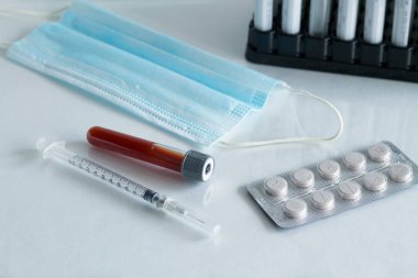 Tıbbi şırınga ve haplar, kan testi tüpü, beyaz arka planda izole edilmiş tıbbi koruyucu maske. Sağlık sigortası. Coronavirus karantinası, hijyen konsepti. Koronavirüsü önle.