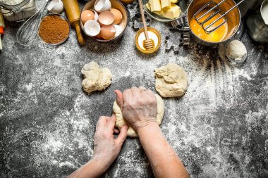 Hamur arka plan. Kadın masada çeşitli malzemelerle hamur kneads.