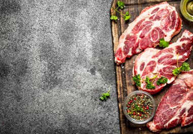 Çiğ et arka plan. Otlar ve baharatlar eski yönetim kurulu ham biftek. Rustik arka plan üzerinde.