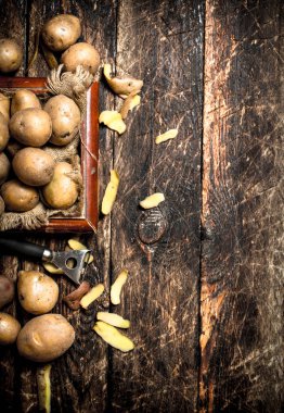 Taze patates içinde eski bir ahşap tepsi. Ahşap arka plan üzerinde.