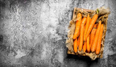 Eski bir kutu içinde organik havuç. Rustik arka plan üzerinde.