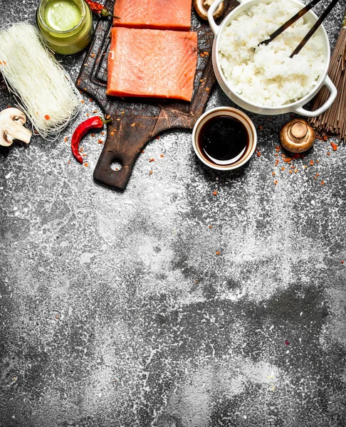 Comida asiática. Arroz hervido con un trozo de salmón y una variedad de ingredientes. Sobre fondo rústico  . — Foto de Stock