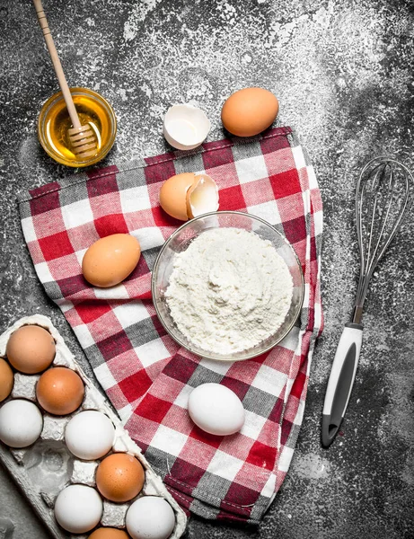 Baking background. Flour and fresh eggs for baking on rustic background .