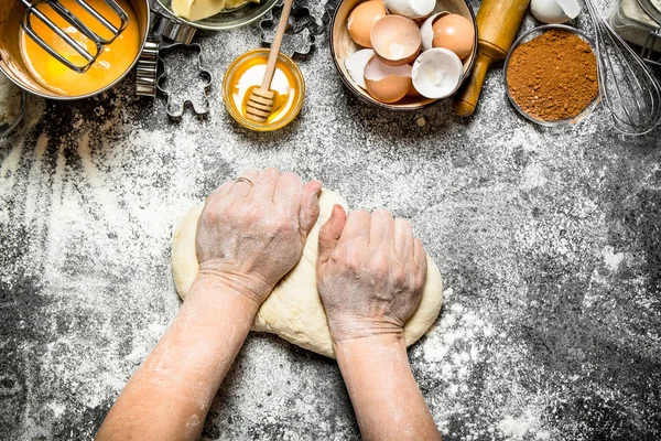 Dough background. Woman kneads dough with various ingredients on the table.