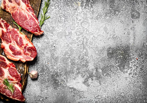 aw meat background. Raw pork with spices and herbs. On a rustic table.