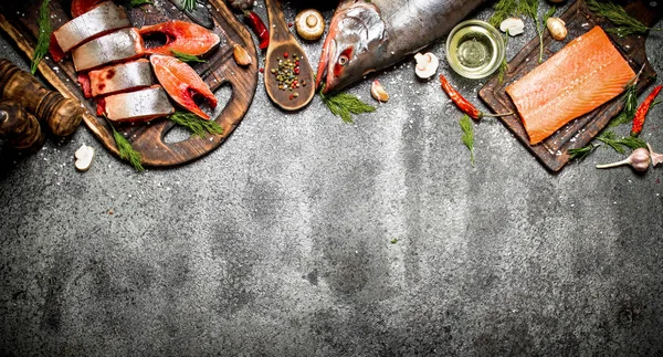 Pescado crudo. Un trozo de salmón fresco con especias en la vieja tabla de cortar. En la mesa rústica . — Foto de Stock