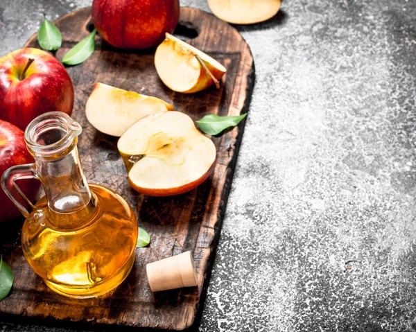 Vinagre de sidra de manzana con manzanas frescas en el tablero de corte . —  Fotos de Stock