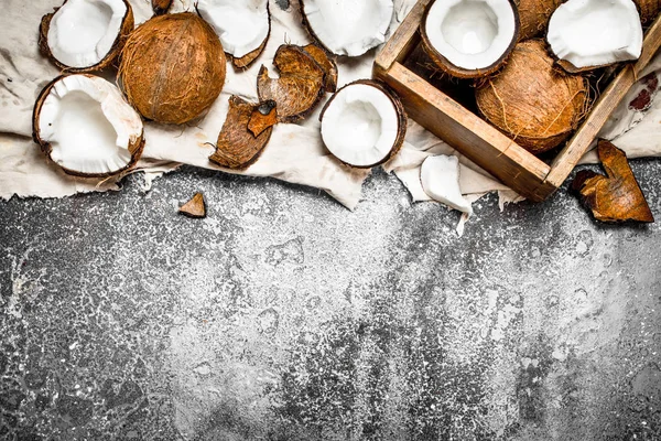 Noix de coco fraîches dans une vieille boîte sur le tissu . — Photo