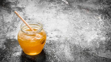 Tahta kaşıkla kavanoza taze bal.