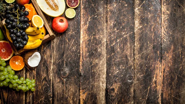 Verschillende rijpe vruchten in een houten doos. — Stockfoto