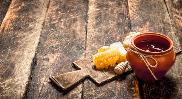 Maceta de miel y panal con una cuchara de madera . — Foto de Stock