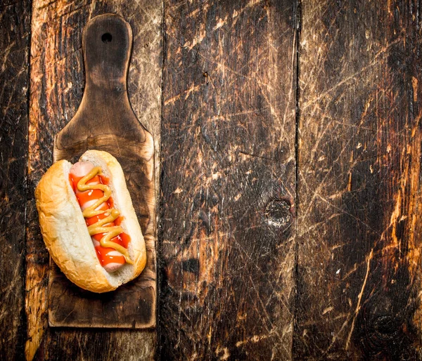 Hotdog com mostarda na placa velha . — Fotografia de Stock