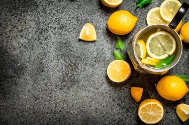 Dilim limon ve yeşil yaprakları ile bir sürahi soğuk limonata.