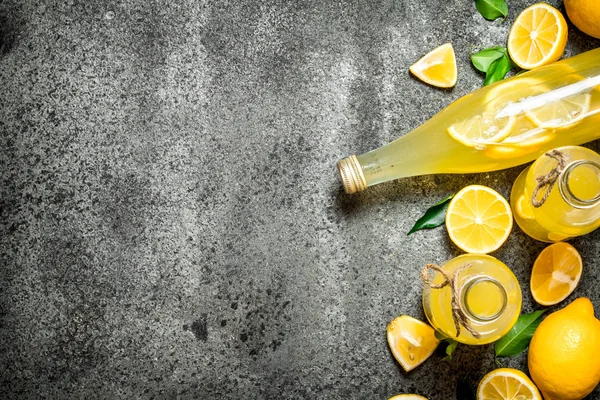 Lemonade in bottles with green leaves. — Stock Photo, Image