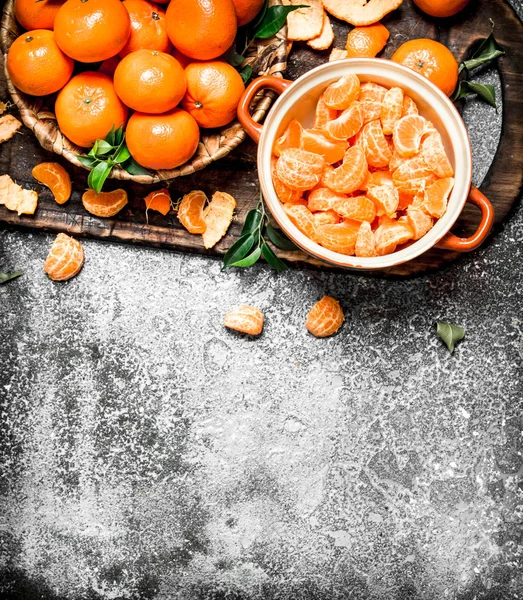 Tangerinas maduras descascadas com folhas verdes . — Fotografia de Stock