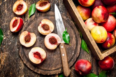 Bir kesme tahtası üzerinde olgun şeftali.