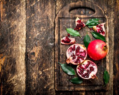 Bir kesme tahtası üzerinde olgun nar.