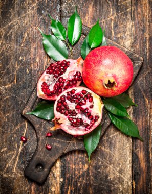 Bir kesme tahtası üzerinde olgun nar.