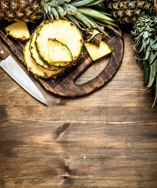Gesneden ananas op een cutting Board met een mes. — Stockfoto