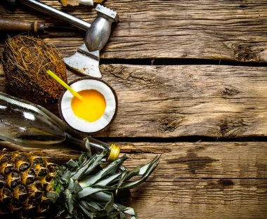 Hindistan cevizi ROM ve ananas ahşap bir masa üzerinde bir fincan taze kokteyl.