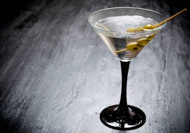 Siyah bir tabloda zeytinli martini. Metin için boş alan.