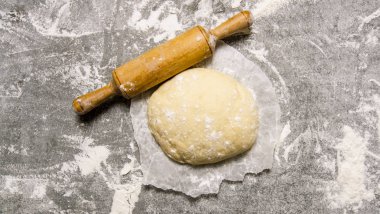  Bir oklava ile kağıt üzerinde hamur. 