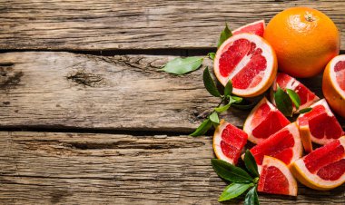 Taze kesilmiş greyfurt ile bırakır. Ahşap masa.