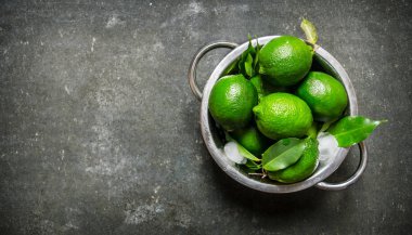 Arka plan kireç. Yaprakları ile bir tencerede taze limes . 