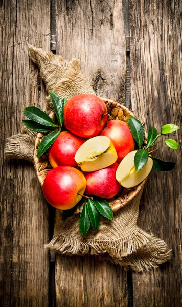 Świeże jabłka czerwone z liści w koszyku. — Zdjęcie stockowe