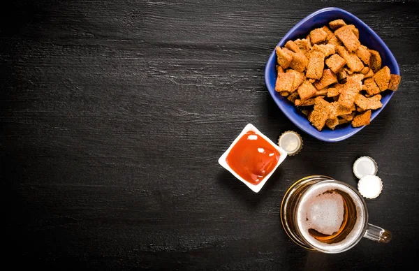Beer with crackers and ketchup on chalkboard. — Stock Photo, Image