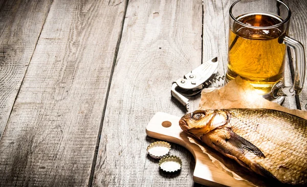 Копченая рыба и свежее пиво на деревянном столе. Свободное место для текста . — стоковое фото