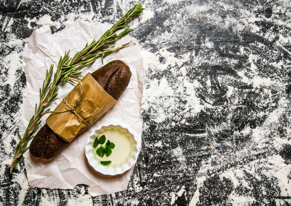 Pão de centeio fresco embrulhado em papel com alecrim . — Fotografia de Stock