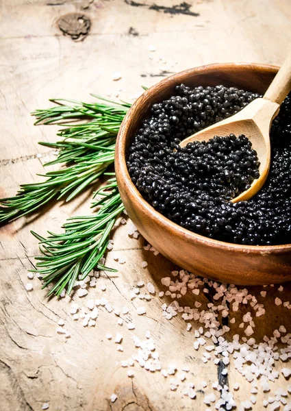 Caviar negro en una taza con romero y sal . — Foto de Stock