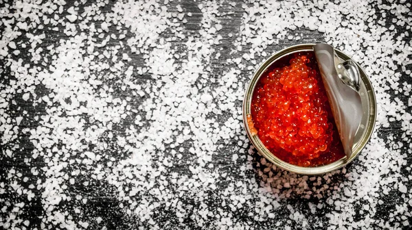 Caviar vermelho em lata de metal com sal. Espaço livre para texto  . — Fotografia de Stock