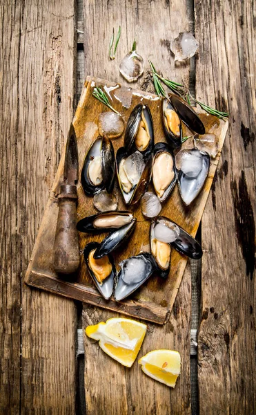 Clams with lemon and ice on a wooden Board. — Stock Photo, Image