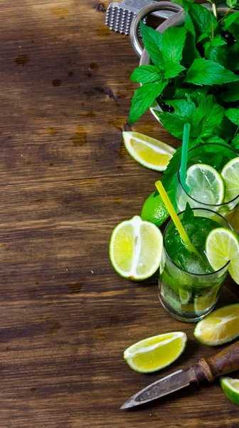 Gli ingredienti per il cocktail lime, rum, foglie di menta, cubetti di ghiaccio sul tavolo di legno . — Foto Stock