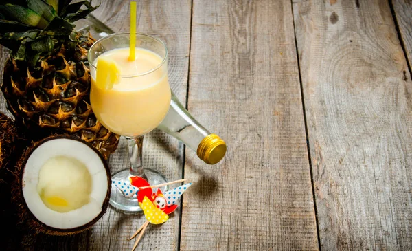 Taze kokteyl cam, ROM, Hindistan cevizi ve ananas ahşap bir masa üzerinde. Metin için boş alan.