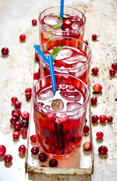 Three berry cocktails with ice and mint leaves on the old rustic background . — Stock Photo, Image