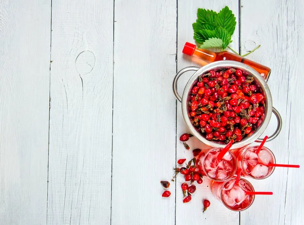 Koktajl z rose hip z lodu i alkohol biały drewniany stół. Ilość wolnego miejsca dla tekstu. — Zdjęcie stockowe