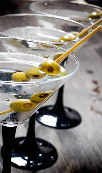 Три мартини с оливками на черном столе . — стоковое фото