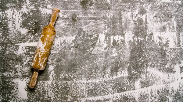 Baking background with a rolling pin with flour.