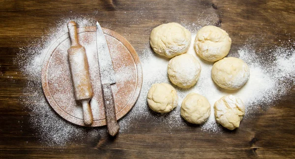 Preparation of the dough. The prepared dough with a rolling pin and knife.