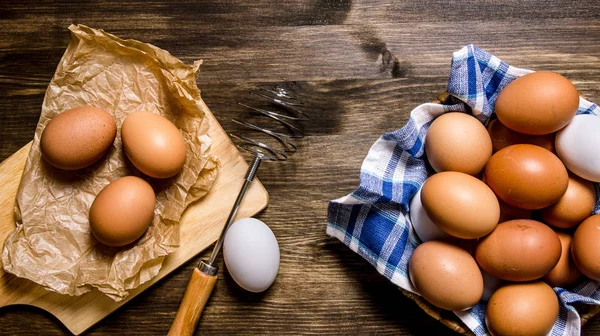 Eggs the background. The eggs in the bowl with the whisk.